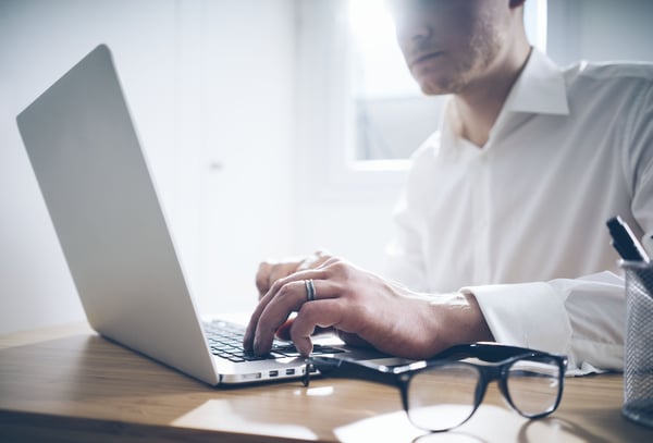 Photo of a business man in a temporay housing unit with a laptop