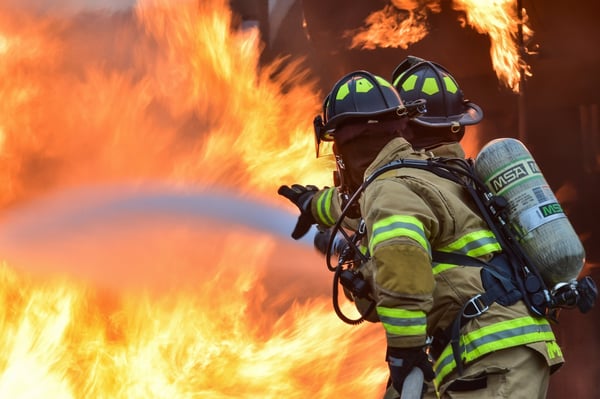 Image of two firefighters fighting a fire