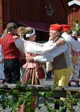 An image of Swedes celebrating Midsommar in traditional attire.