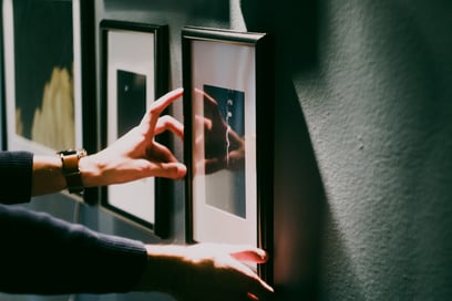 Image of a person hanging a picture in a temporary housing apartment