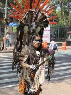 An image of a streetperformer dressed in native gear on the streets of Polanco.