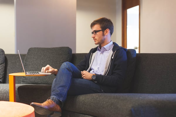 An image of a man using his laptop on the couch