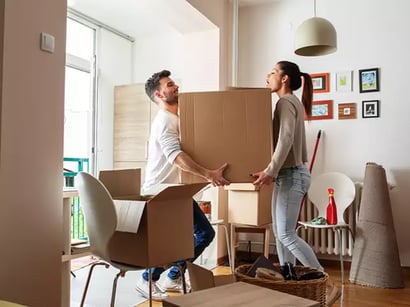 photo of a man and woman moving into a new home